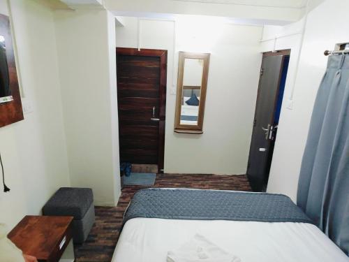 a small room with a bed and a door at Hotel Buddha Mitra in Ravangla