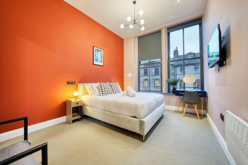 a bedroom with orange walls and a bed and a window at Grand Central Station 2 Bed Apartment A1 in Glasgow