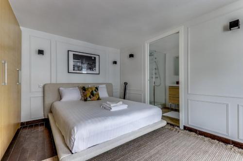 une chambre blanche avec un lit et un miroir dans l'établissement Le Moka - Duplex & Bright- Near Champs-Elysées, à Paris