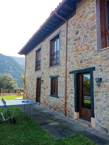 a ping pong table in front of a stone house at Villa Mogrovejo in Mogrovejo