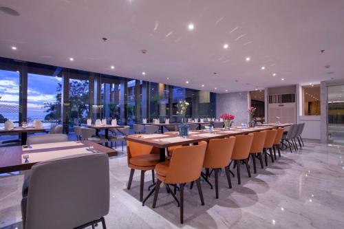 a dining room with a long table and chairs at Balcony Seaside Sriracha Hotel & Serviced Apartments in Si Racha