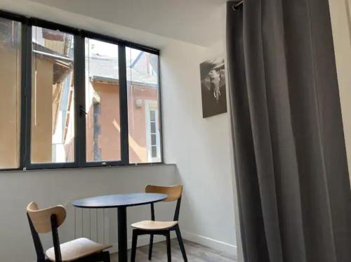 une pièce avec une table et deux chaises et une fenêtre dans l'établissement studio centre-ville historique, à Chambéry