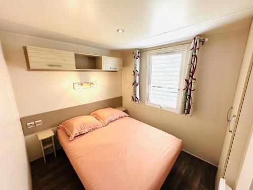 - un petit lit dans une petite chambre avec fenêtre dans l'établissement Mobile home op camping de Pujol in Argeles-Sur-Mer, à Argelès-sur-Mer