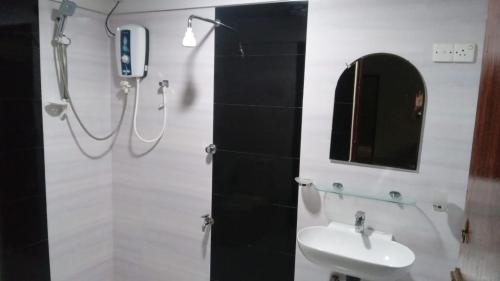 a bathroom with a sink and a shower and a mirror at Hotel SU kataragama in Kataragama