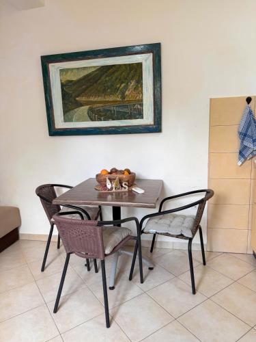 a dining room table with chairs and a painting on the wall at Ilijada apartments in Igalo