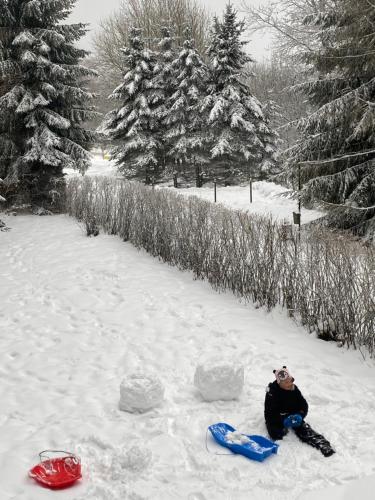 a person is sitting in the snow at Samostatný apartmán se zahradou in Bedřichov