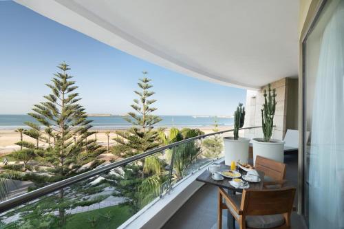 a balcony with a table and a view of the beach at Atlas Essaouira Riad Resort in Essaouira
