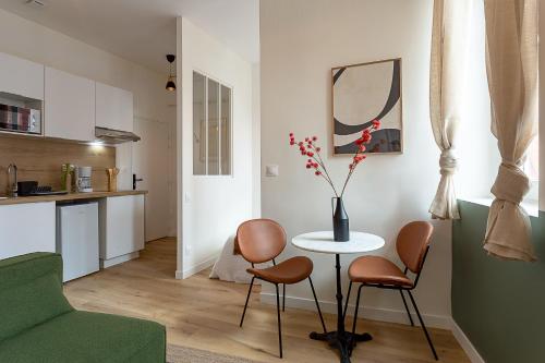 un salon avec une table et des chaises et une cuisine dans l'établissement Le Tisserand - Appartement Cosy proche de la Gare, à Toulouse