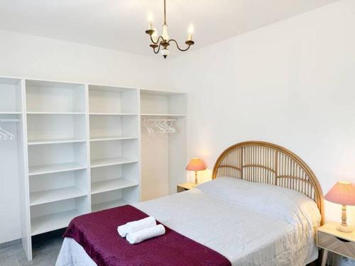 - une chambre avec un grand lit et des étagères blanches dans l'établissement Maison à 15 minutes de Propriano, à Santa-Maria-Figaniella