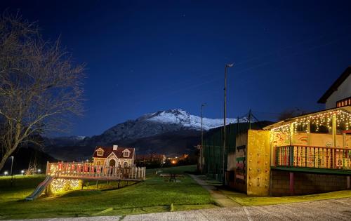 a snow covered mountain in the distance behind a building at Apartamentos Alquitara in Potes