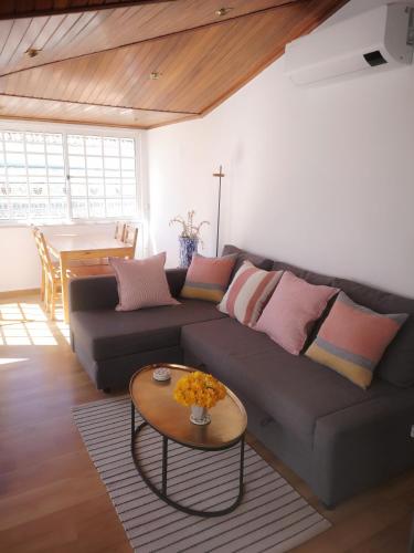 a living room with a couch and a table at Plage,15 m, mer, Casa Melissa by SesimbraSunSea in Sesimbra