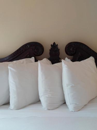 a pile of white pillows on a bed at Studio-hôtel Villegiature Saint-Sauveur in Piedmont