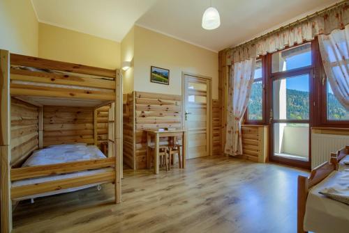 a bedroom with a bed and a table in a room at Schronisko PTTK Trzy Korony in Sromowce Niżne