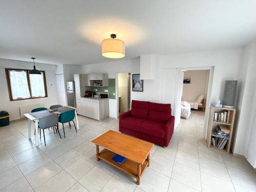 un salon avec un canapé rouge et une table dans l'établissement Le Relai des Gayots Wifi Parking Jardin - CLG Savoie, à Châteauneuf
