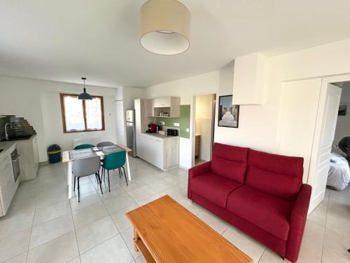 un salon avec un canapé rouge et une table dans l'établissement Le Relai des Gayots Wifi Parking Jardin - CLG Savoie, à Châteauneuf