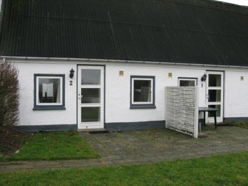 a white house with a bench in front of it at Sorø Camping & Cottages in Sorø