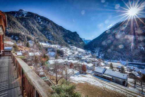 a view of a town with a train in the mountains at Hotel Grischuna Filisur in Filisur