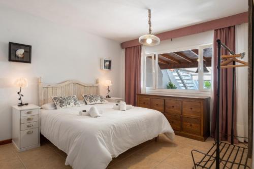 ein Schlafzimmer mit einem großen weißen Bett und einem Fenster in der Unterkunft Apartamento Cipreses in Puerto del Carmen