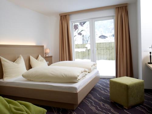 a bedroom with a bed and a large window at Apart Resort Rabl in Westendorf
