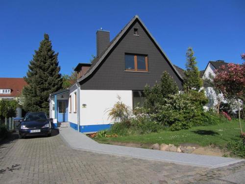 a black and white house with a car parked in the driveway at Appartement Lübeck St. Lorenz in Lübeck