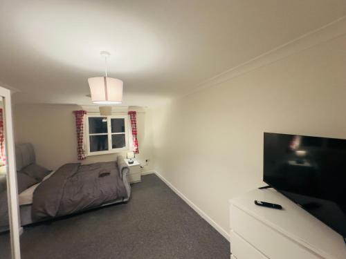 a bedroom with a bed and a flat screen tv at Comfortable Double Rooms in a Beautiful House in Ipswich
