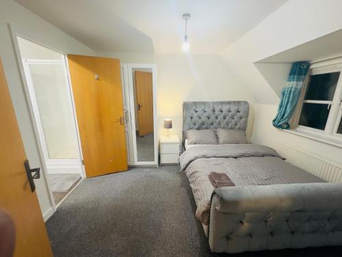 a bedroom with a bed with a tufted headboard at Comfortable Double Rooms in a Beautiful House in Ipswich