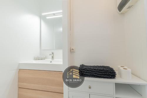 une salle de bain blanche avec un lavabo et un miroir dans l'établissement L'Europole - 3 chambres proche gare, à Grenoble
