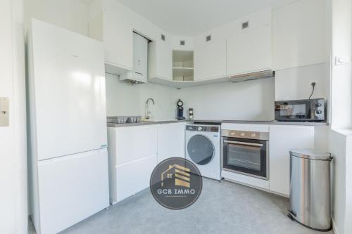une cuisine blanche avec des armoires et des appareils blancs dans l'établissement L'Europole - 3 chambres proche gare, à Grenoble