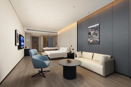 a living room with a white couch and a table at Atour Hotel Haikou International Duty Free City in Haikou