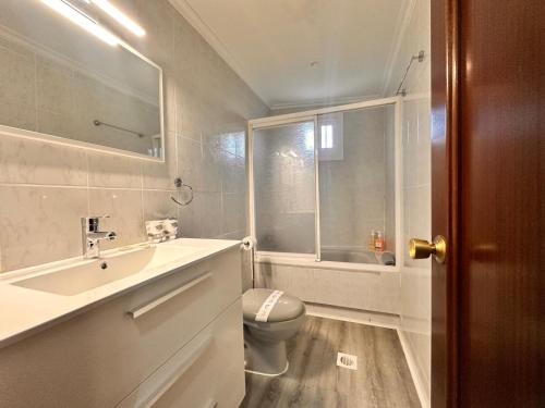 a bathroom with a sink and a toilet and a window at Casa Independiente en Quintela - HomeyGalicia in Vigo