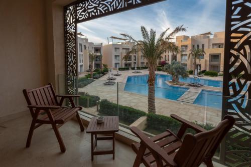a balcony with chairs and a view of a swimming pool at El Gouna - BIRD NEST in Hurghada