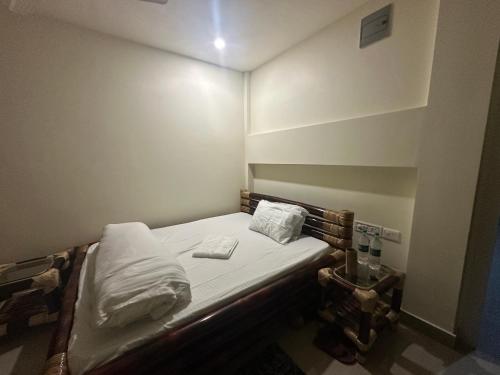 a small room with a bed with two pillows on it at Niribili Homestay in Majuli