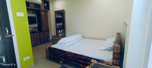a small bedroom with a bed in a room at Niribili Homestay in Majuli