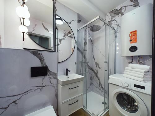 a bathroom with a sink and a washing machine at ApartamentuSnu, Sportowa I in Radom