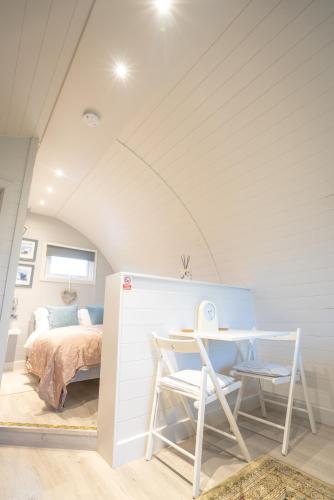 a bedroom with a bed and a table and a desk at Hood Lane Farm - The Pod - Luxury Glamping Holiday Lodge in Arley