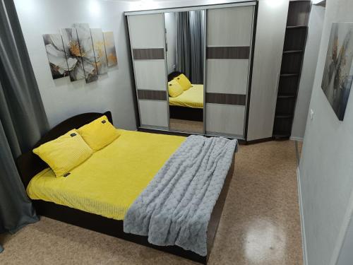a bedroom with a bed and a large mirror at Современные апартаменты в центре города in Ustʼ-Kamenogorsk