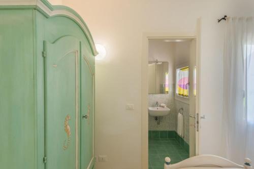 a bathroom with a green cabinet and a sink at Baia Bianca Apartments Sardinia in Baja Sardinia
