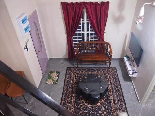 a room with a staircase with a chair and a window at D'Binjai Homestay & Roomstays Kuala Kangsar in Kuala Kangsar