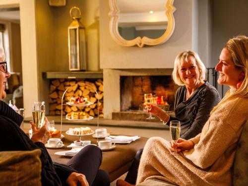 a group of people sitting around a table with wine glasses at Sunday Box Hill Burford Bridge Hotel in Dorking