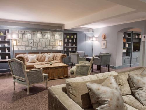 a living room with couches and a table and chairs at Sunday Box Hill Burford Bridge Hotel in Dorking