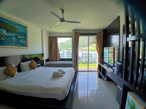 a bedroom with a bed and a flat screen tv at SM Patong Resort in Patong Beach