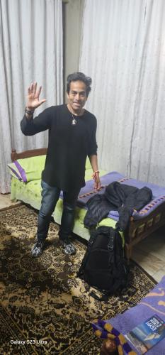 a man is standing next to a bed at Ashraf Hostel Guest house in Aswan
