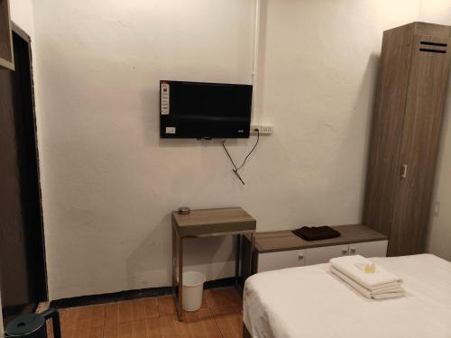 a room with a bed and a tv on the wall at The Spring in Pattaya Central