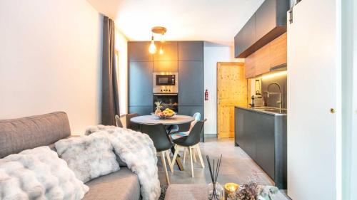 un salon avec un canapé et une table et une cuisine dans l'établissement Les Fermes de Saint Sorlin H 103 - 2P6, à Saint-Sorlin-dʼArves