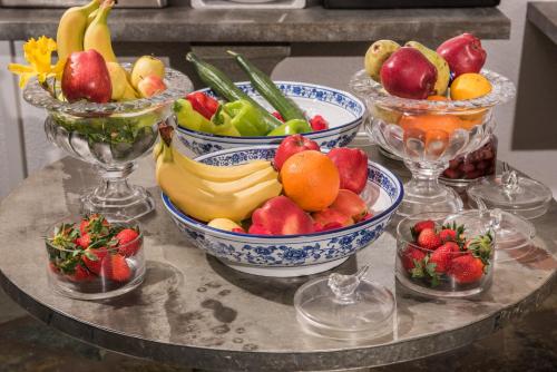 a table topped with bowls of fruit and vegetables at Leandros Hotel in Nea Roda