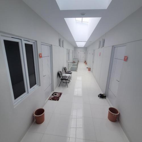 an empty hallway with chairs and tables and windows at Nadamax House Syariah in Bonorejo