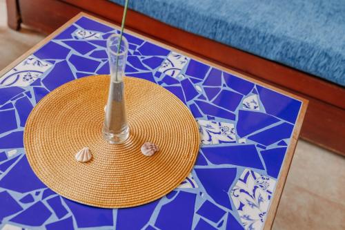 a straw table with a straw hat on a blue and white floor at Hotel Apartamentos Londres La Manga in La Manga del Mar Menor