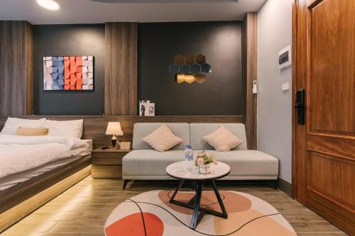 a bedroom with a bed and a couch and a table at My Home Westlake Hanoi in Hanoi