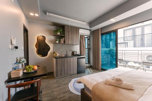 a bedroom with a large bed and a kitchen at My Home Westlake Hanoi in Hanoi