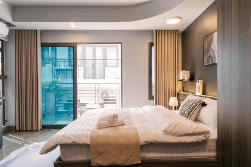 a bedroom with a large bed and a large window at My Home Westlake Hanoi in Hanoi